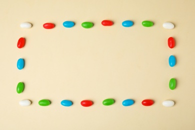 Frame of jelly beans on color background, top view. Space for text