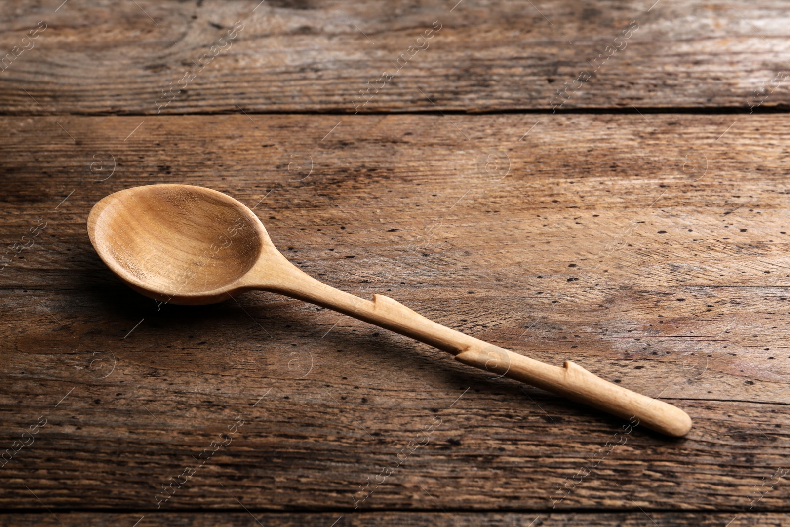 Photo of New clean empty spoon on wooden background