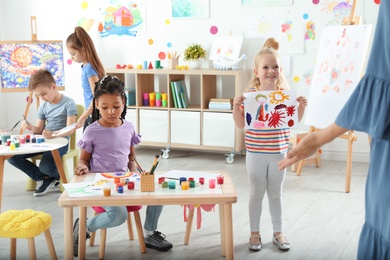 Photo of Cute little children at painting lesson indoors