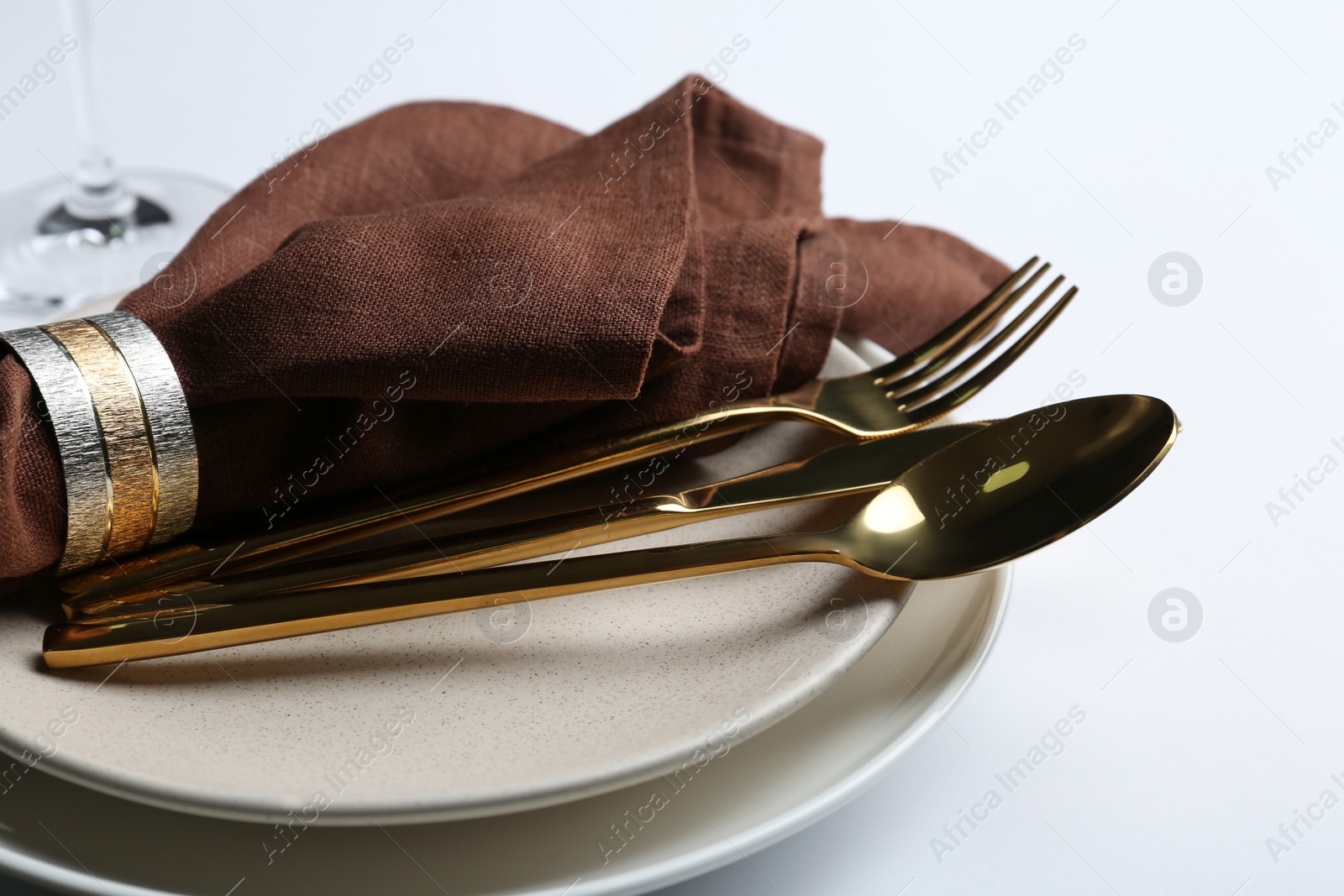 Photo of Stylish elegant cutlery with napkin in plate on white background, closeup