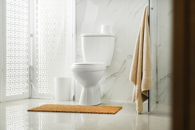 Photo of Toilet bowl near shower stall in modern bathroom interior