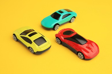 Photo of Different bright cars on yellow background. Children`s toys