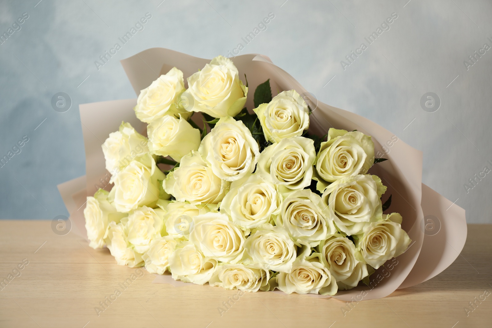 Photo of Luxury bouquet of fresh roses on wooden table