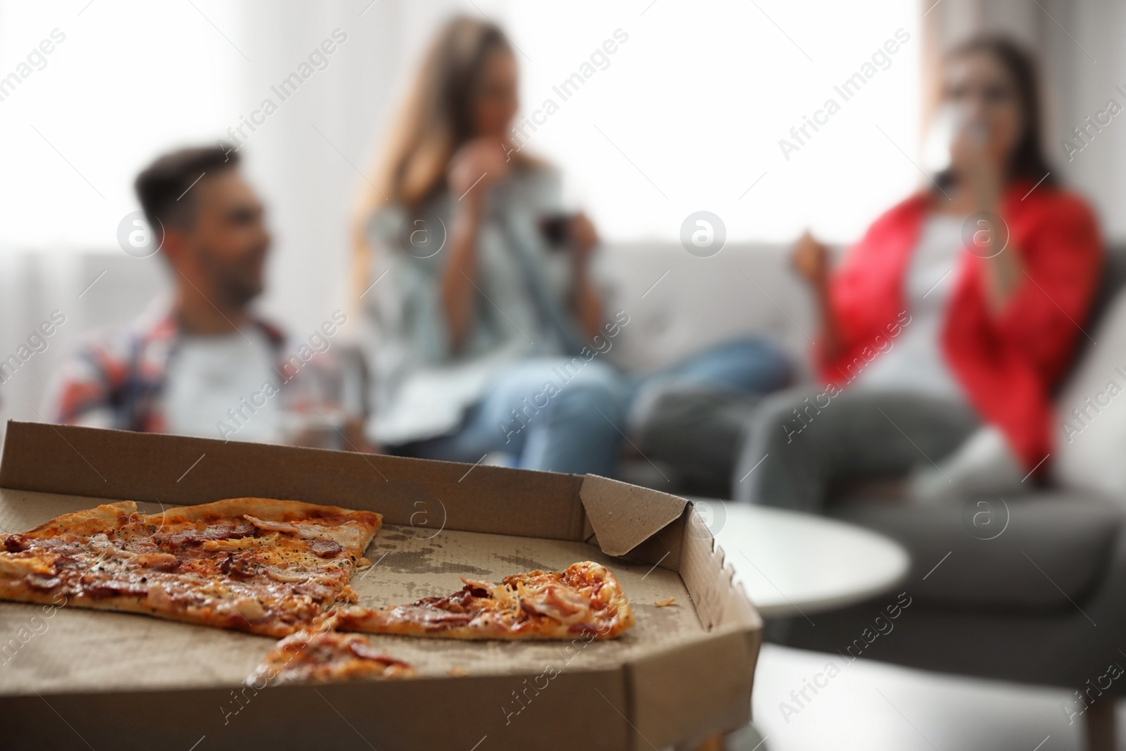 Photo of Group of friends having party at home, focus on pizza