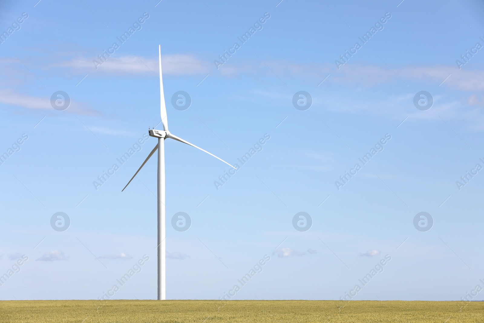 Photo of Beautiful view of field with wind turbine. Alternative energy source