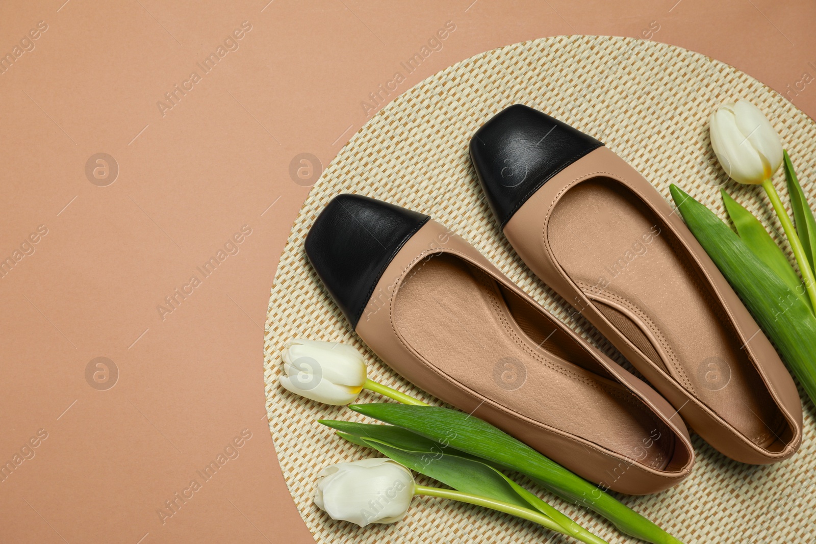 Photo of Pair of new stylish square toe ballet flats and beautiful tulips on beige background, flat lay. Space for text