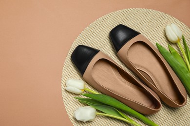 Photo of Pairnew stylish square toe ballet flats and beautiful tulips on beige background, flat lay. Space for text