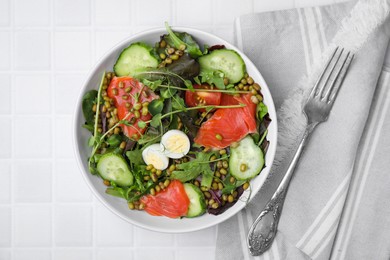 Photo of Bowl of salad with mung beans on white tiled table, flat lay