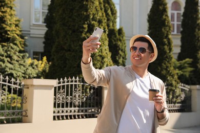 Happy man taking selfie on city street