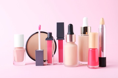 Photo of Different luxury decorative cosmetics on pink background