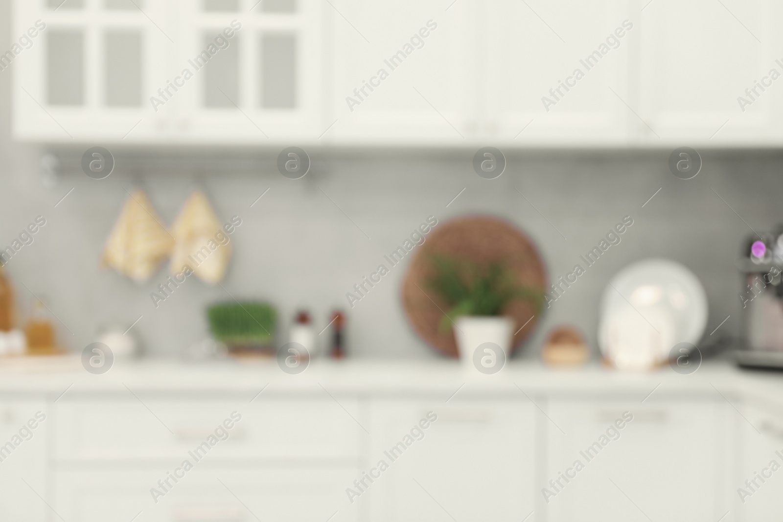 Photo of White cosy kitchen with furniture, blurred view. Interior design