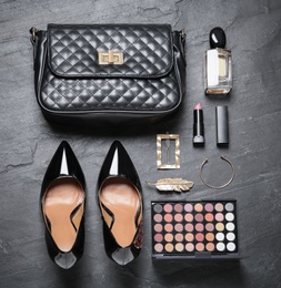 Photo of Flat lay composition with stylish women's shoes and cosmetic products on black background