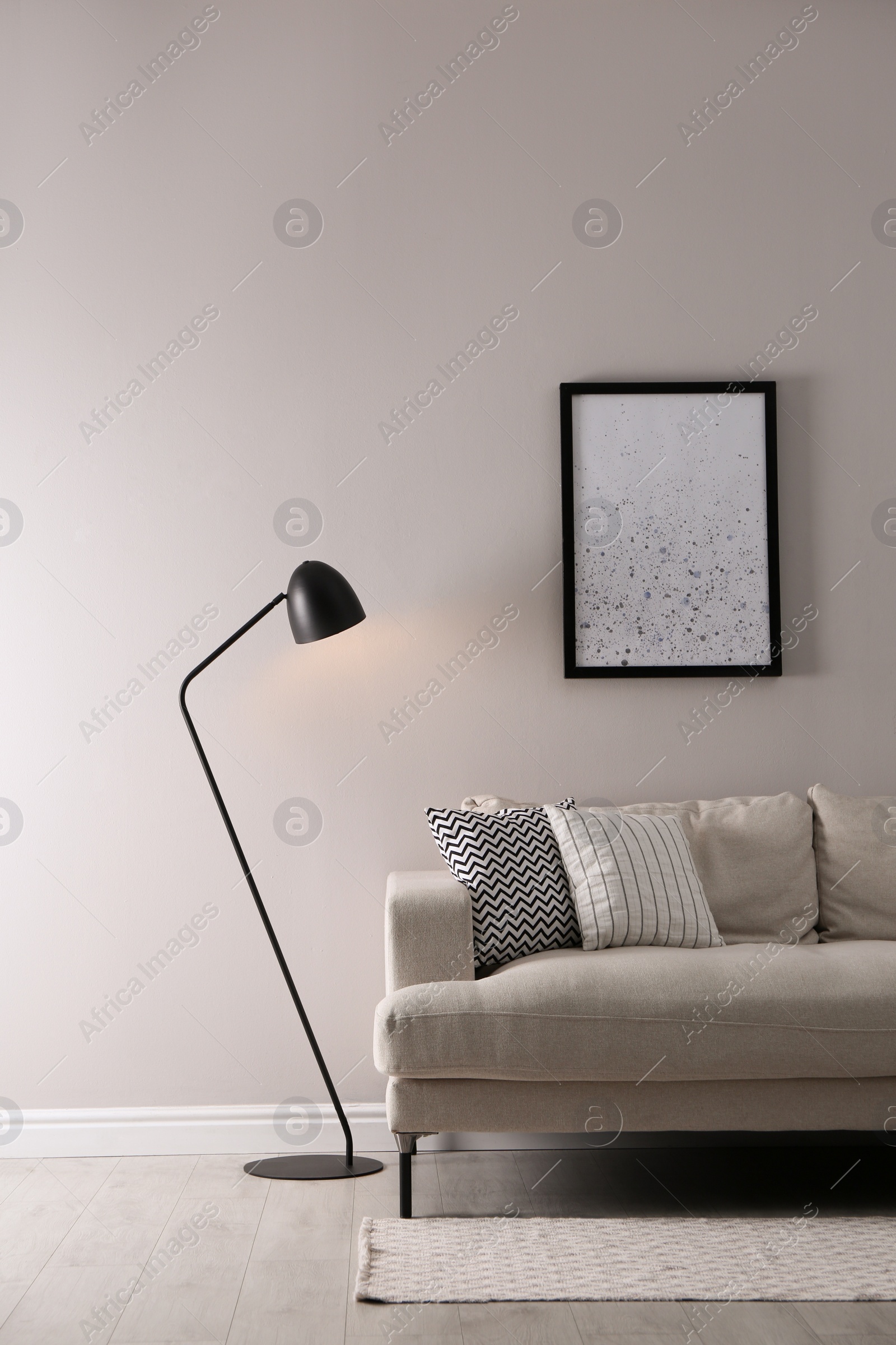 Photo of Stylish living room interior with comfortable sofa and floor lamp. Space for text