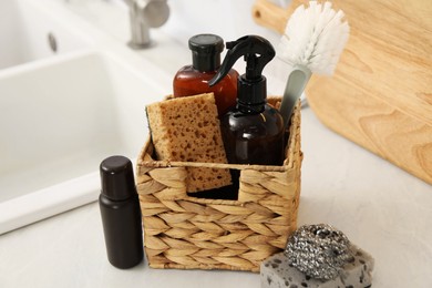 Different cleaning supplies in basket on countertop