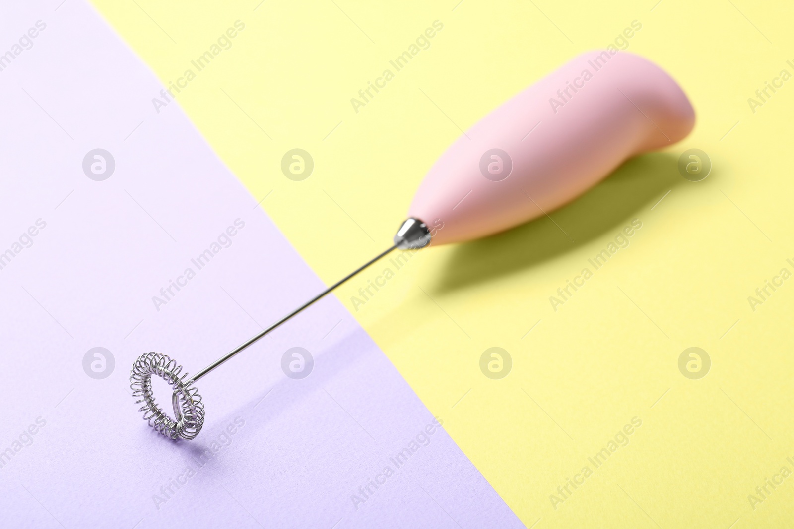 Photo of Pink milk frother wand on color background