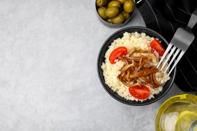 Photo of Tasty couscous with mushrooms and tomatoes served on grey table, flat lay. Space for text