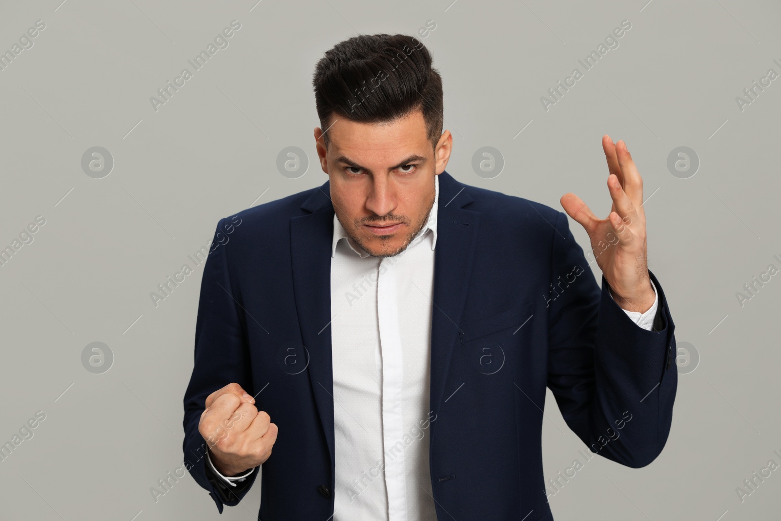 Photo of Angry man on grey background. Hate concept