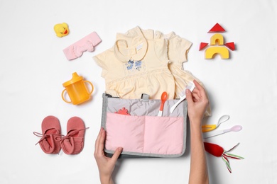 Photo of Woman with maternity bag and baby accessories on white background, top view