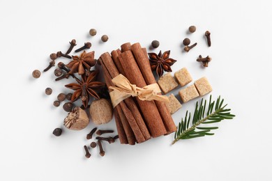 Photo of Different spices, nuts and fir branch on white table, flat lay