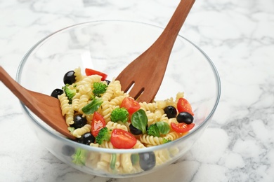 Glass bowl with delicious pasta primavera on table