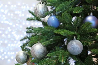 Christmas tree with festive decor against blurred fairy lights