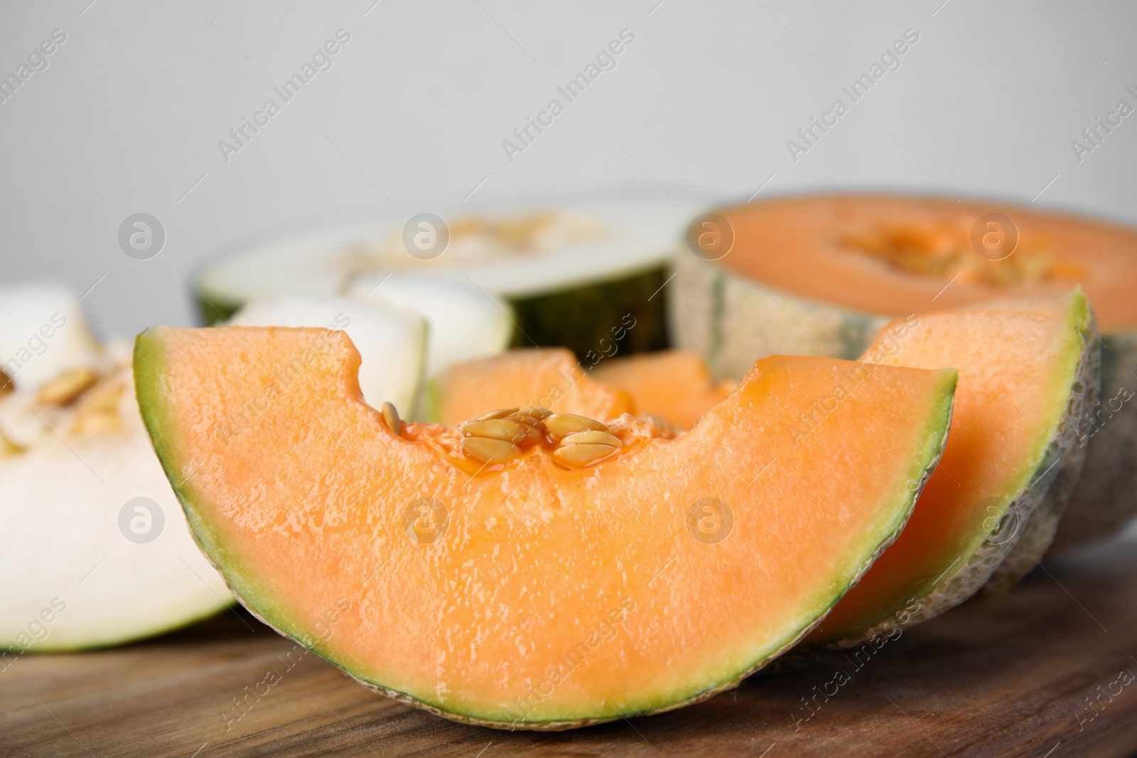 Photo of Tasty colorful ripe melons on wooden board, closeup