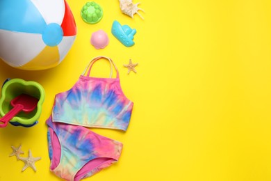 Photo of Flat lay composition with beach ball and sand toys on yellow background, space for text
