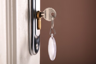 Photo of Key with fob in door lock, closeup. Space for text