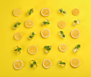 Photo of Lemonade layout with juicy lemon slices, ice and mint on yellow background, top view