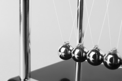 Newton's cradle on light background, closeup. Physics law of energy conservation