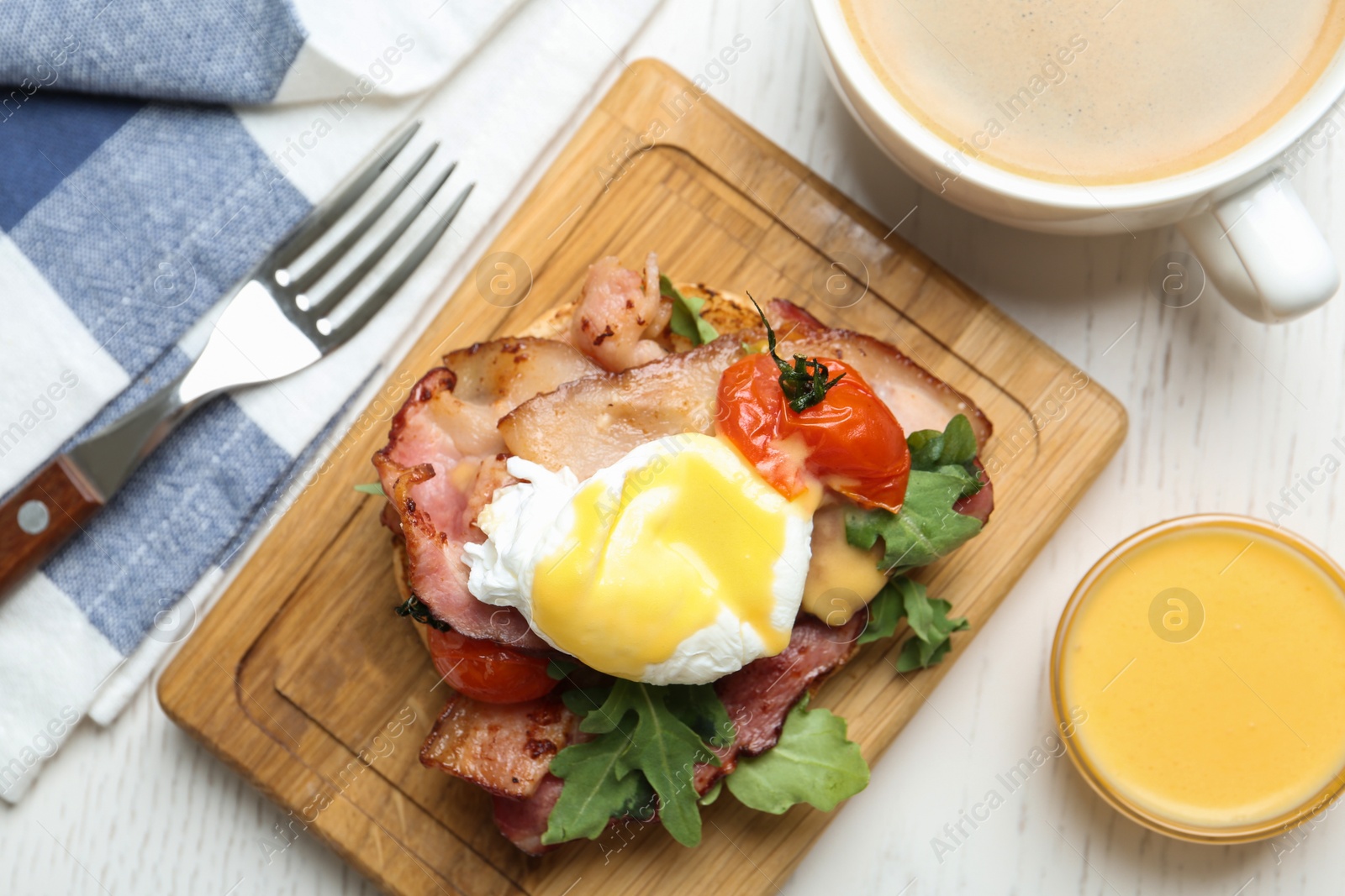 Photo of Delicious egg Benedict served on white wooden table, flat lay