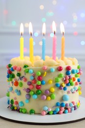 Photo of Cute bento cake with tasty cream and burning candles on white wooden table