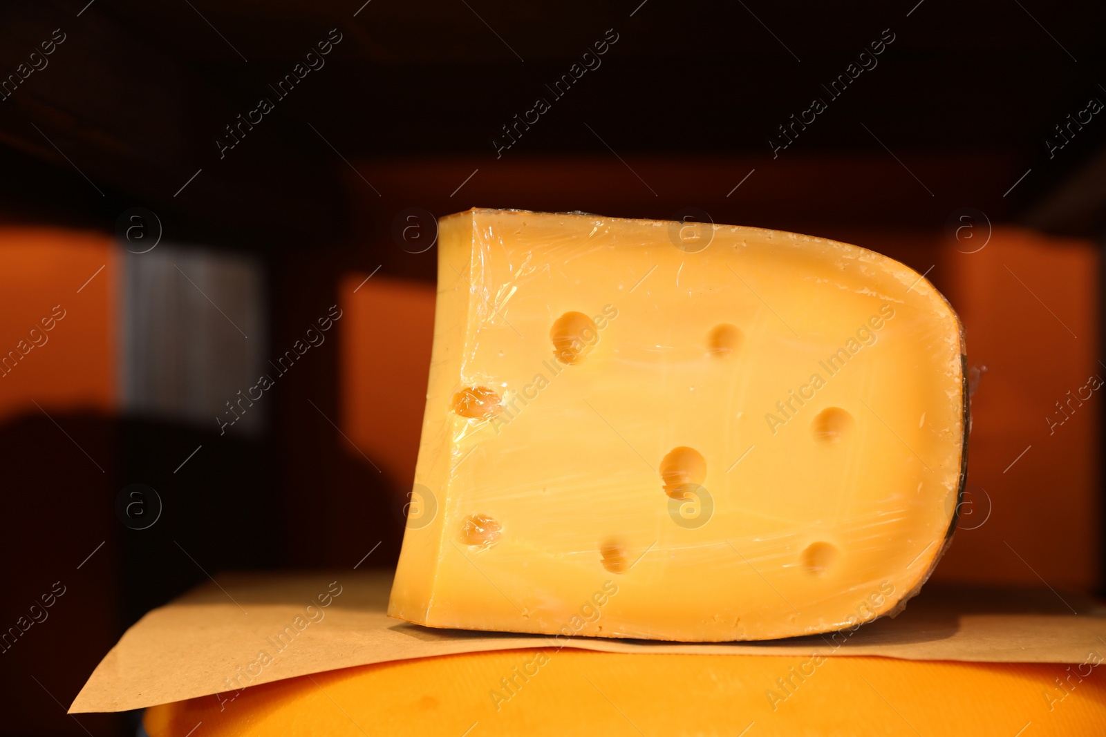 Photo of Delicious cheese in store, closeup. Dairy product