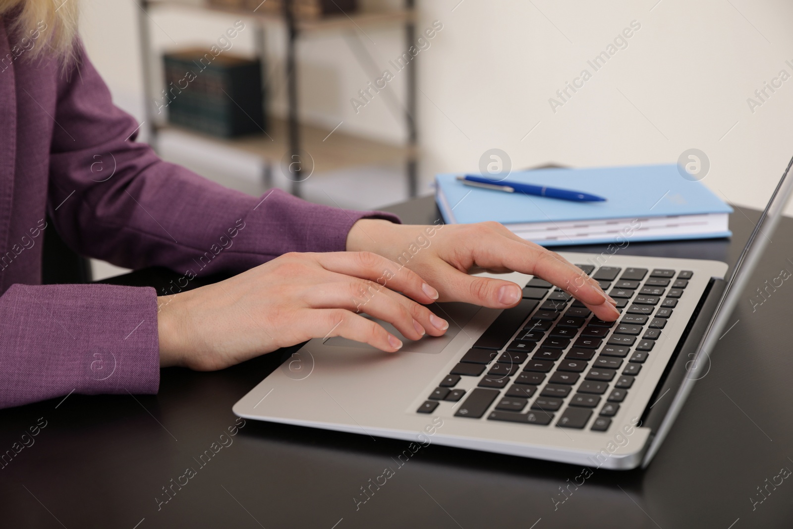 Image of Woman working on laptop at table, closeup