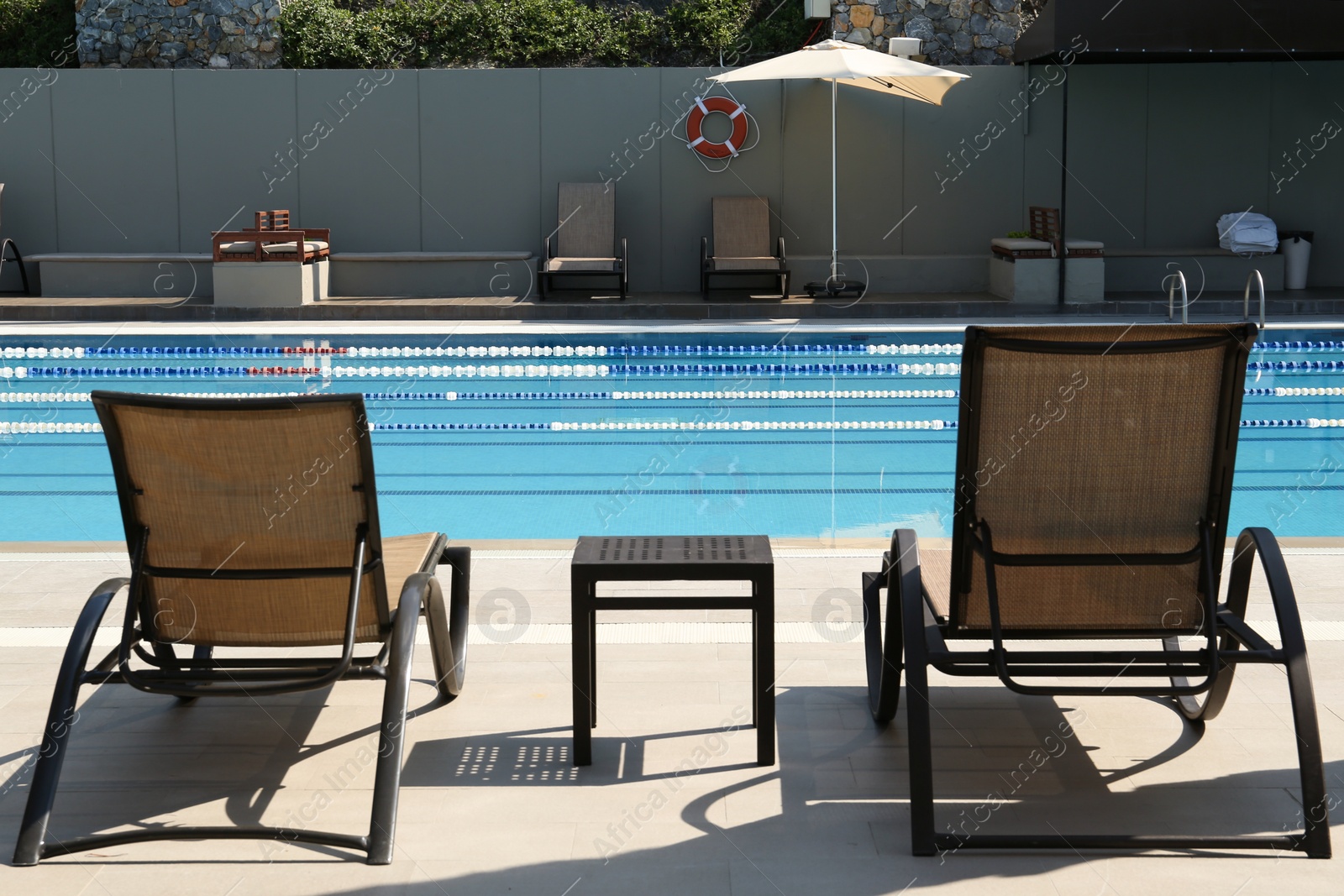 Photo of Empty sunbeds near outdoor swimming pool at resort