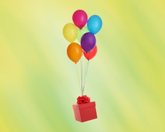 Many balloons tied to red gift box on yellowish green background