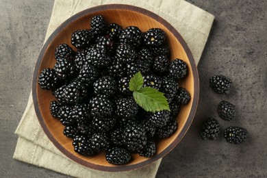 Bowl with fresh ripe blackberries on dark grey table, flat lay