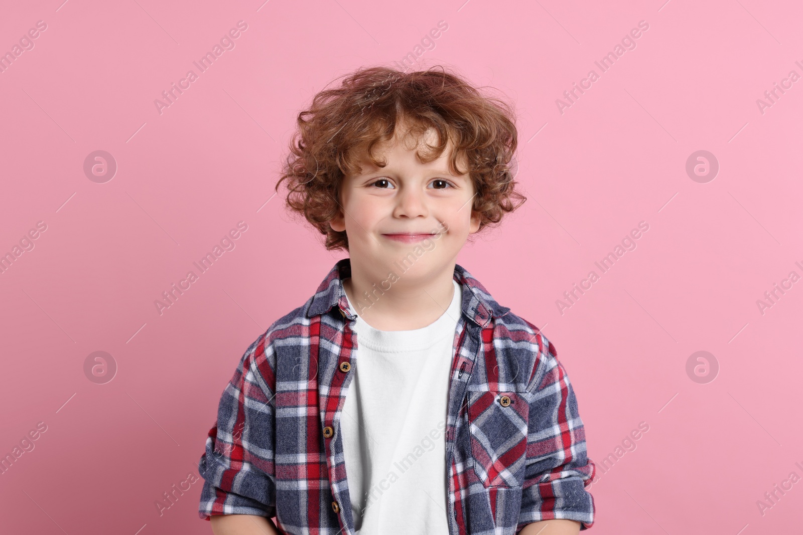 Photo of Portrait of cute little boy on pink background