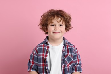 Portrait of cute little boy on pink background