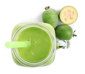 Photo of Fresh feijoa smoothie in mason jar and fresh fruits on white background, top view