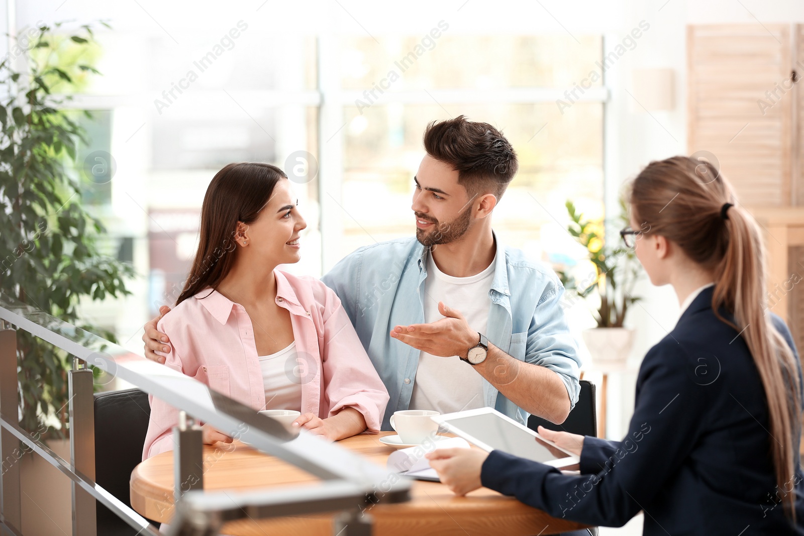 Photo of Female insurance agent working with young couple in office