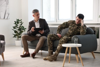 Professional psychotherapist working with military man in office