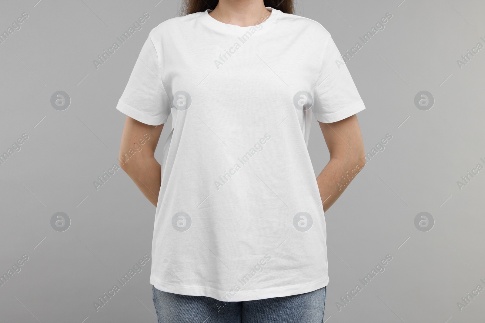 Photo of Woman in white t-shirt on grey background, closeup