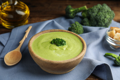 Photo of Delicious broccoli cream soup served on wooden table