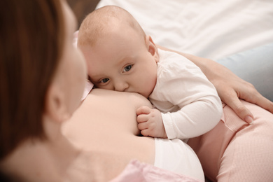 Young woman breast feeding her little baby, above view