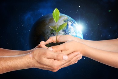 Image of Make Earth green. Woman and man holding soil with green seedling in hands, closeup. Globe in space on background
