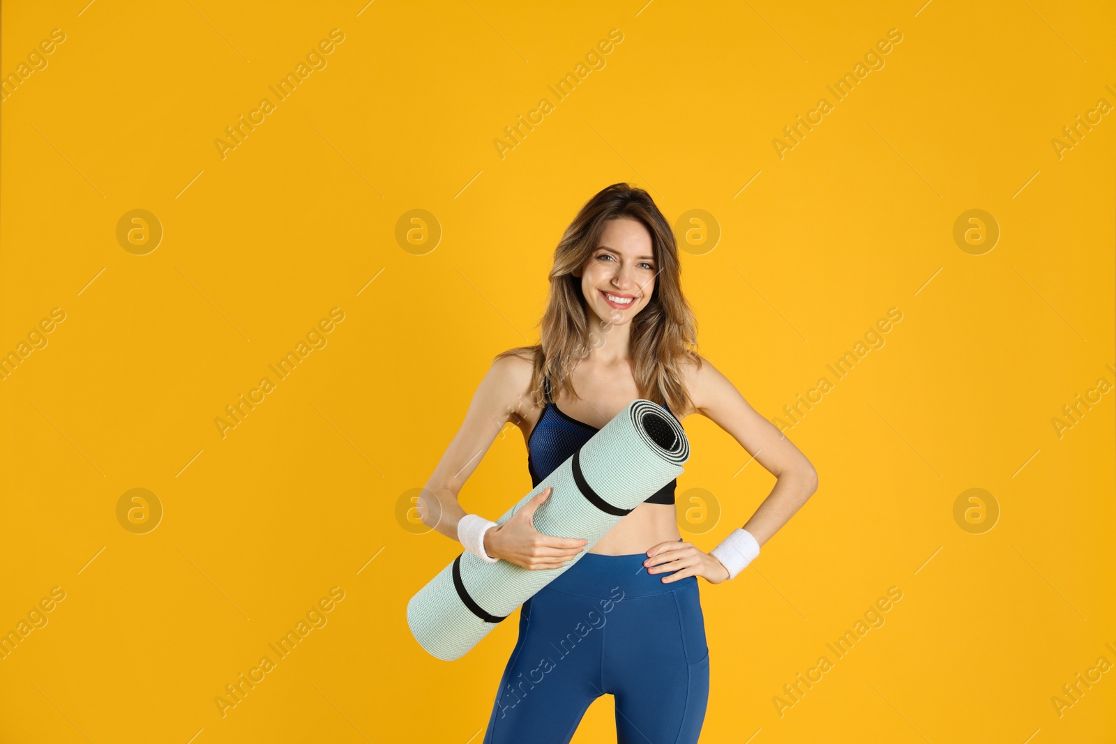 Photo of Beautiful woman with yoga mat on yellow background