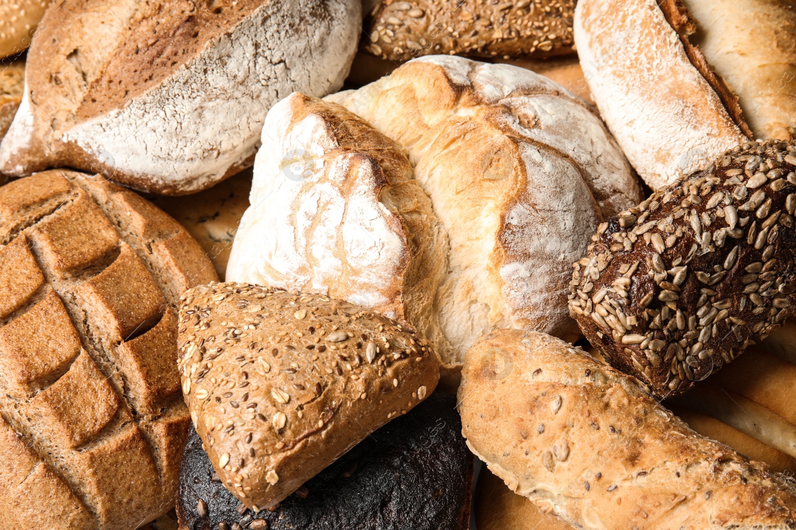 Photo of Different kinds of fresh bread as background, closeup