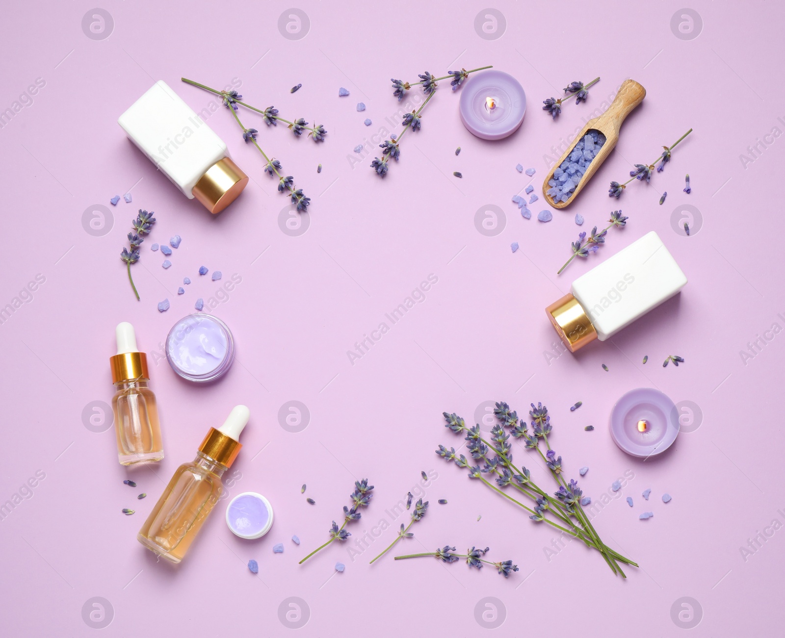 Photo of Frame made with lavender flowers and natural cosmetic products on pink background. Space for text