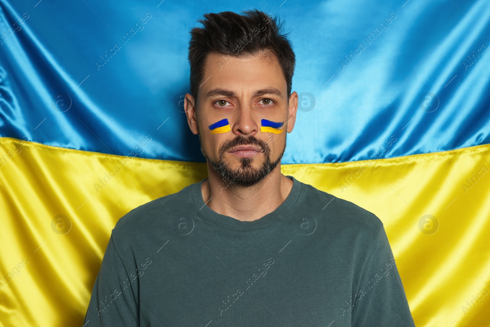 Photo of Man with face paint near Ukrainian flag